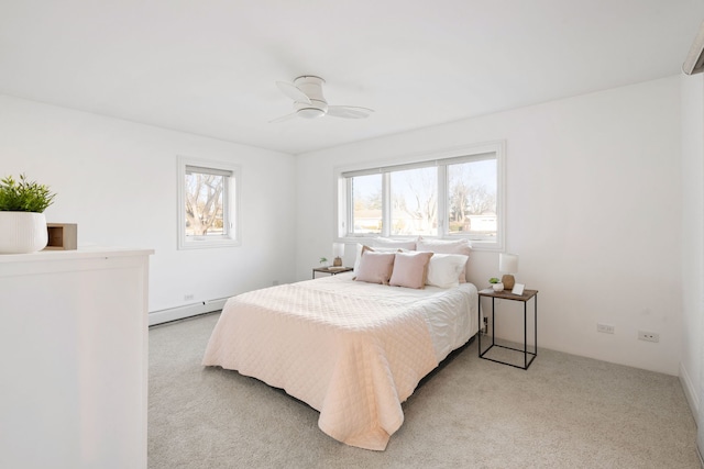 bedroom with light carpet, a baseboard heating unit, and ceiling fan