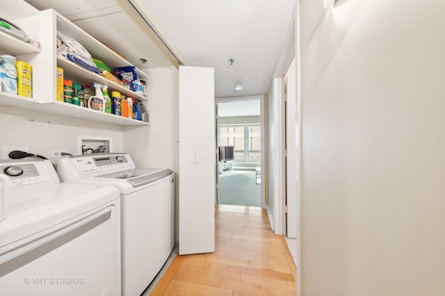 laundry room featuring washer and dryer and light hardwood / wood-style flooring