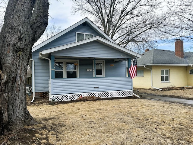 bungalow-style house with a front lawn and covered porch