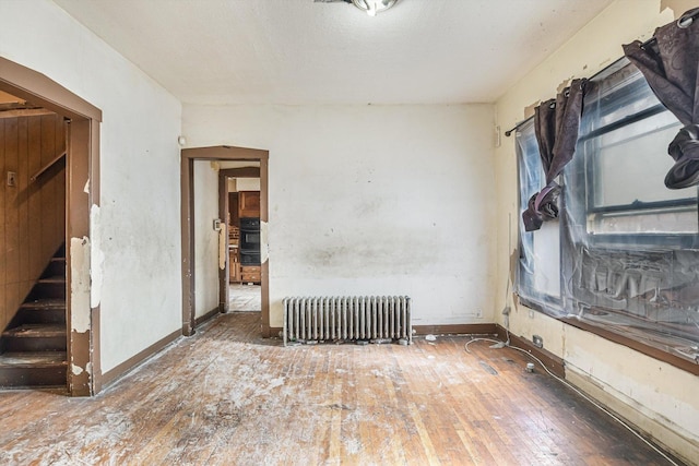 spare room with hardwood / wood-style flooring and radiator