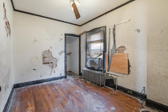 empty room featuring crown molding, radiator, and dark hardwood / wood-style floors