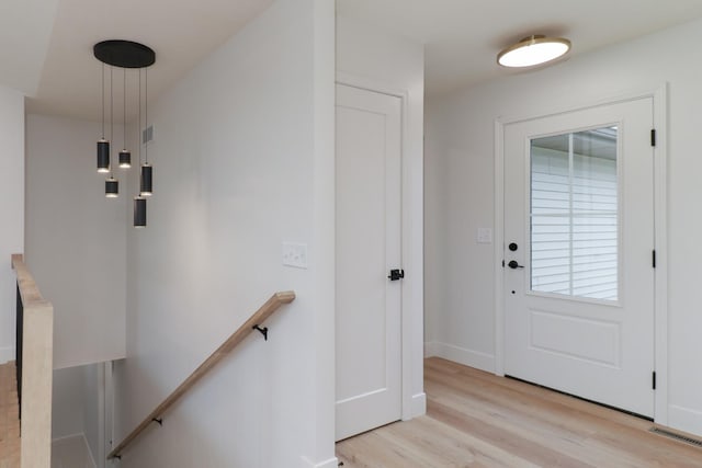 entrance foyer featuring light wood-style floors, visible vents, and baseboards
