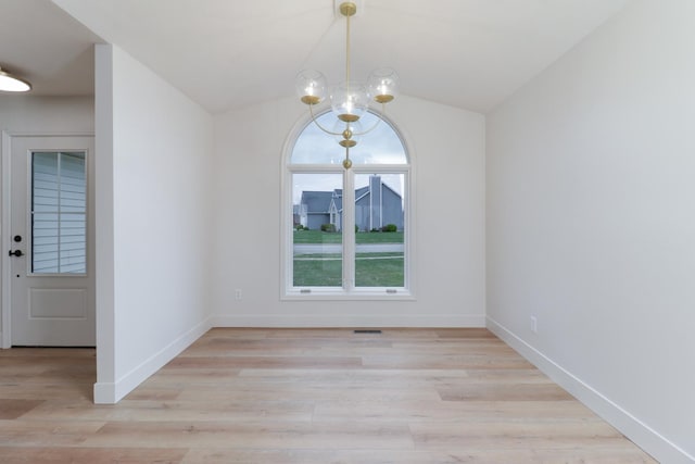 unfurnished dining area with lofted ceiling, baseboards, light wood-type flooring, and an inviting chandelier
