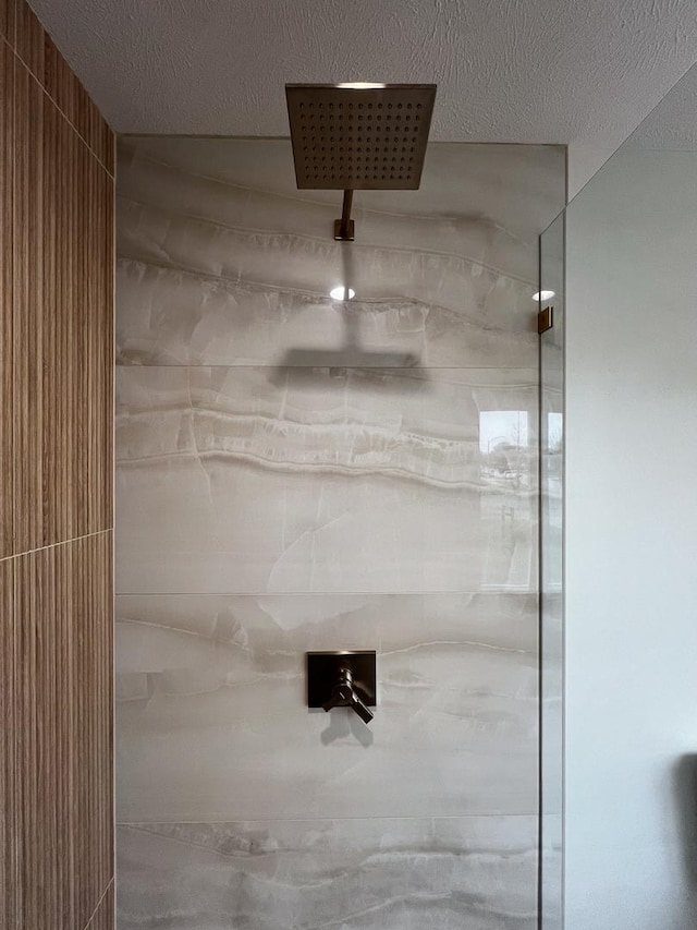 details with a tile shower and a textured ceiling