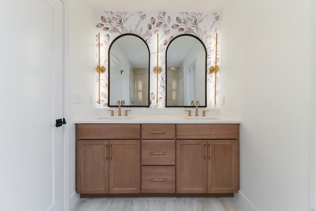 full bathroom with baseboards, a sink, and double vanity
