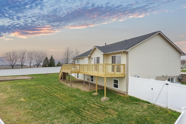 back of property with a lawn, a fenced backyard, stairs, and a deck