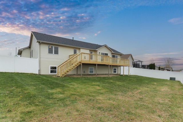 back of property featuring a lawn, a fenced backyard, stairway, and a deck