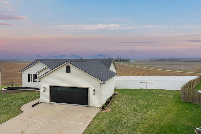view of front of home with fence, a shingled roof, and a yard