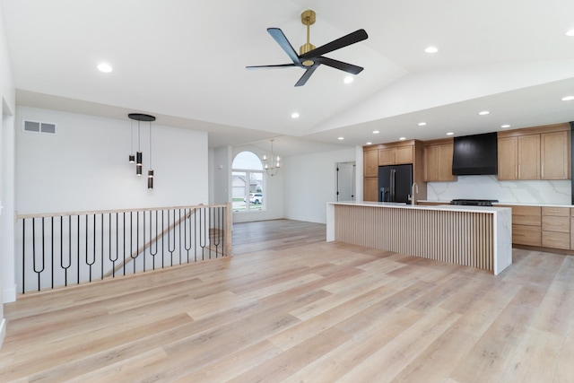 kitchen featuring light countertops, visible vents, a center island with sink, black fridge with ice dispenser, and custom range hood