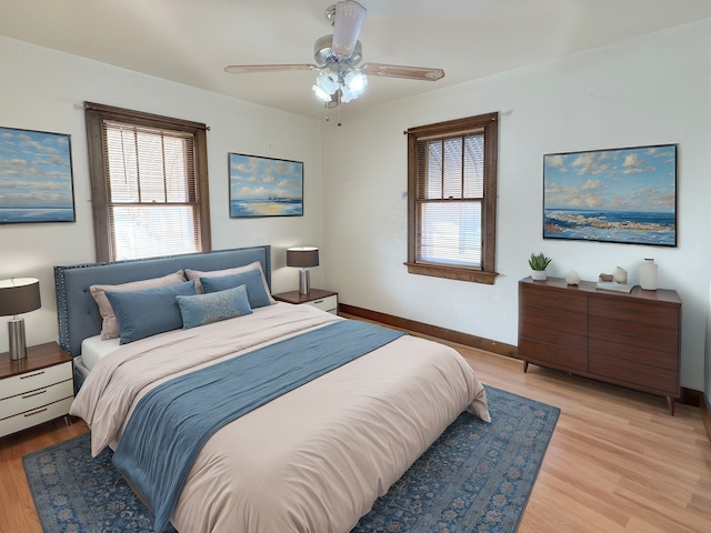 bedroom with multiple windows, ceiling fan, and light wood-type flooring