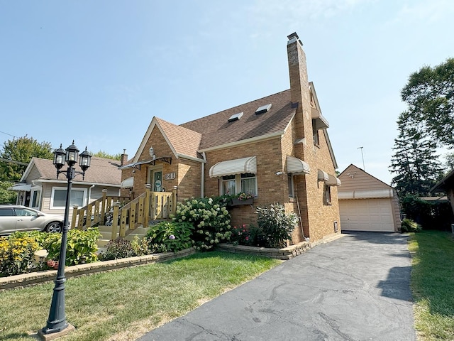 view of front of home with a garage, an outbuilding, and a front yard