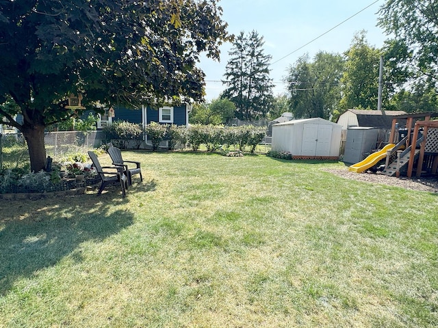 view of yard with a storage shed and a playground