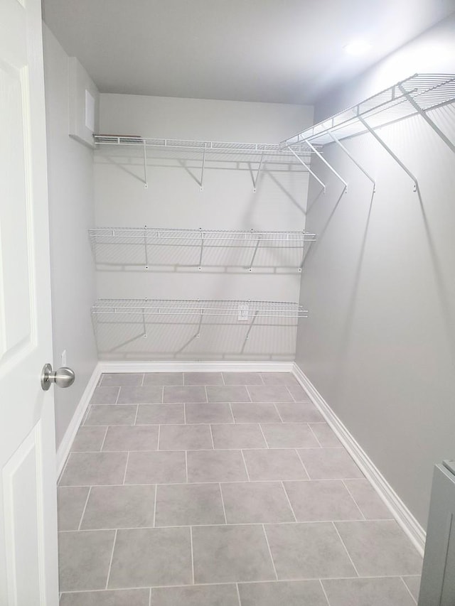 walk in closet with tile patterned floors