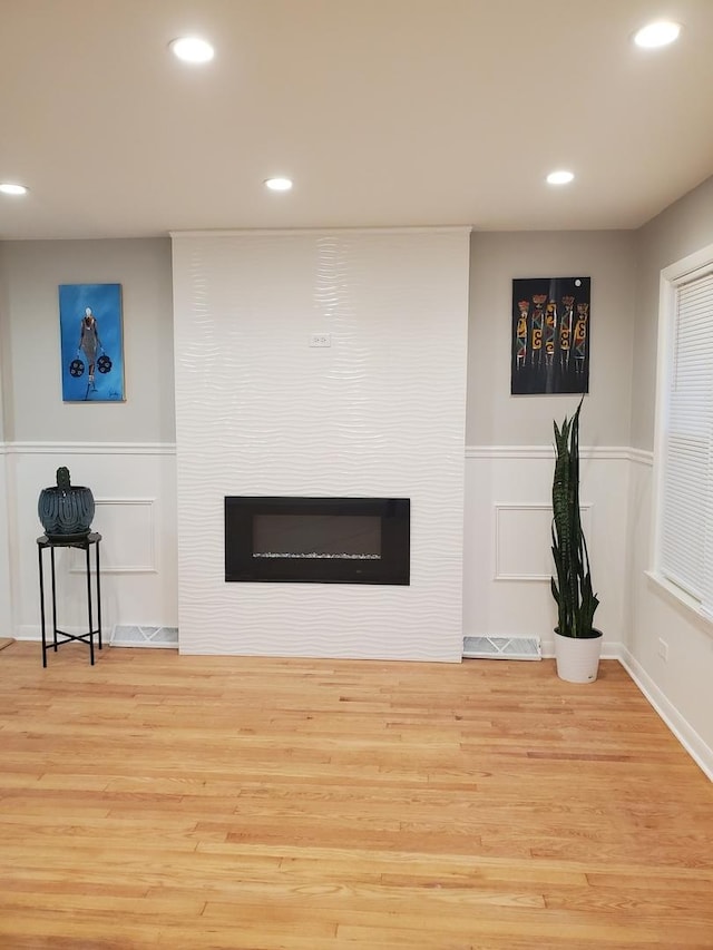 details featuring hardwood / wood-style flooring and a large fireplace