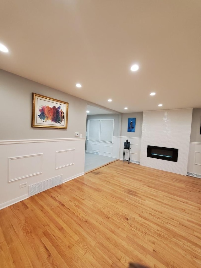 unfurnished living room with a large fireplace and light hardwood / wood-style floors