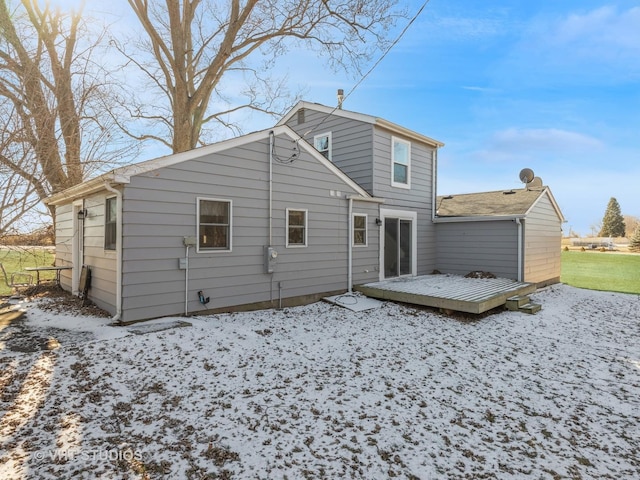 snow covered rear of property with a wooden deck