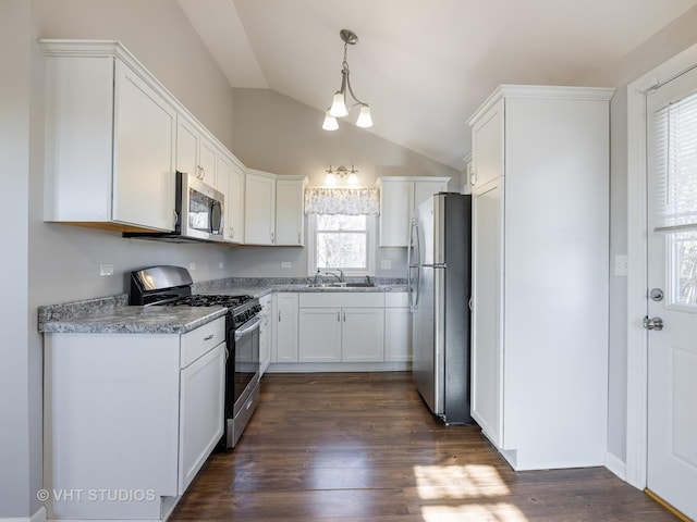 kitchen with appliances with stainless steel finishes, sink, white cabinets, dark hardwood / wood-style flooring, and hanging light fixtures