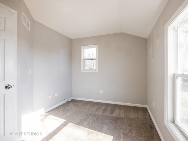 spare room with vaulted ceiling and carpet floors