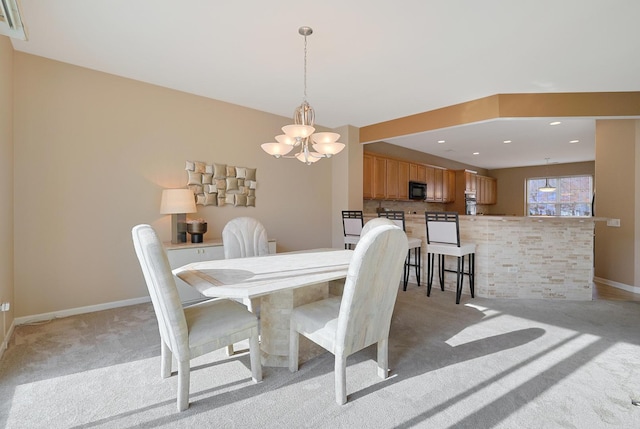 dining room with light colored carpet and a chandelier