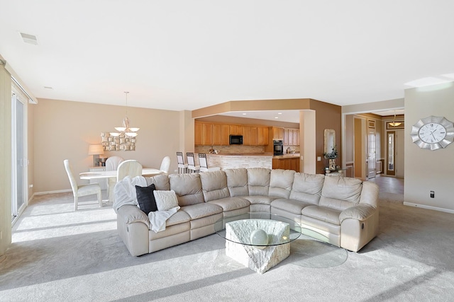 carpeted living room featuring a chandelier