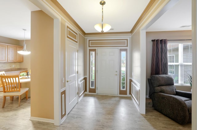 entryway with ornamental molding and light wood-type flooring