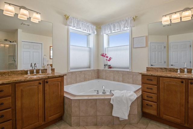 bathroom with a closet, two vanities, a sink, and tile patterned floors