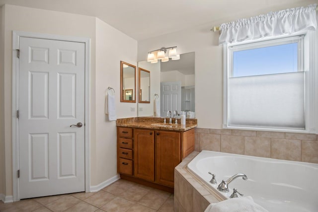 bathroom featuring tile patterned flooring, a garden tub, and vanity