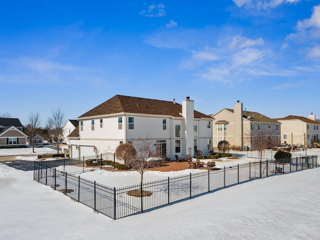 view of front facade featuring a garage, a residential view, fence, and driveway