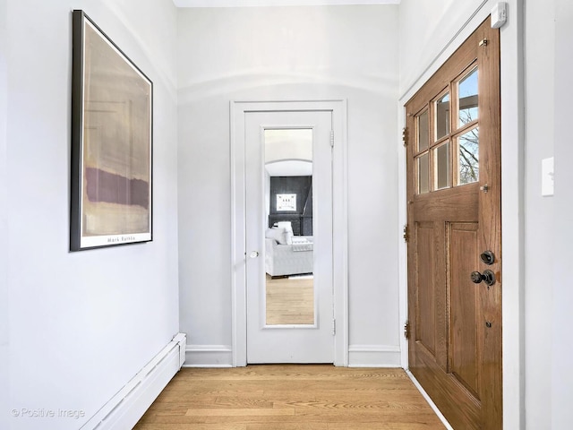 interior space with light wood-type flooring, baseboards, and a baseboard heating unit