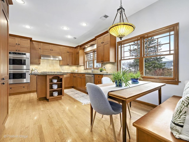 kitchen featuring appliances with stainless steel finishes, range hood, backsplash, and open shelves