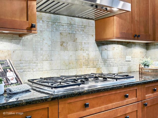 kitchen featuring tasteful backsplash, brown cabinets, stainless steel gas stovetop, and exhaust hood