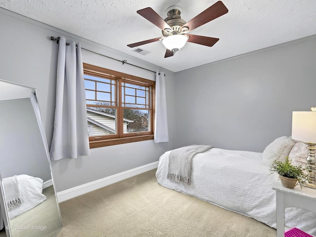 carpeted bedroom featuring a ceiling fan, baseboards, visible vents, and a textured ceiling