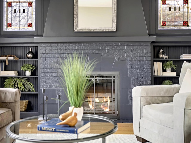 interior space featuring a glass covered fireplace and wood finished floors