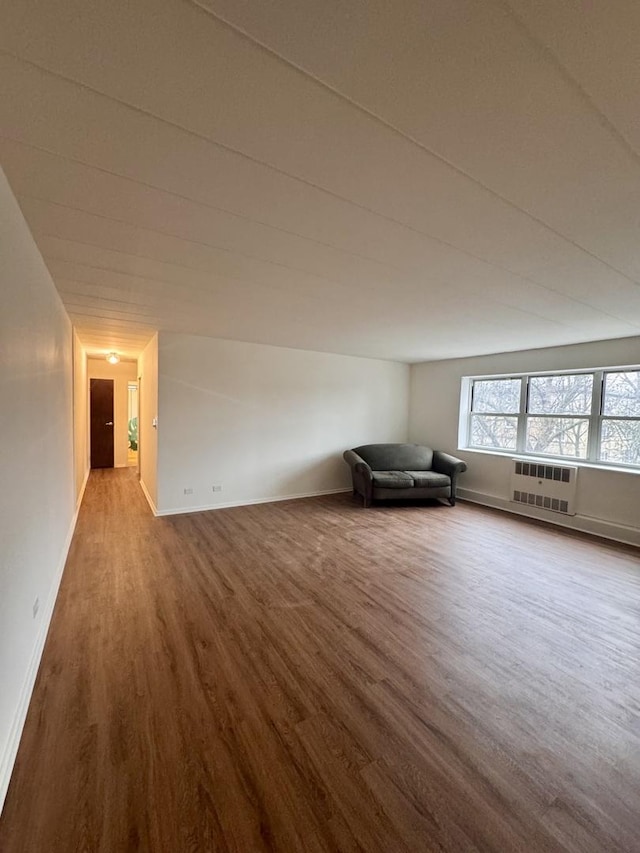 bonus room with an AC wall unit and hardwood / wood-style floors