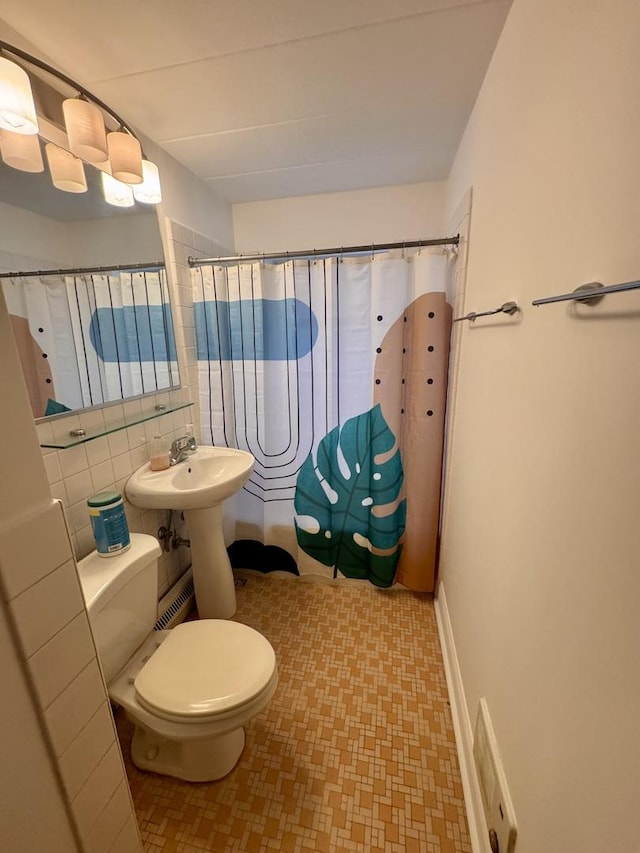 bathroom featuring sink, toilet, a shower with shower curtain, and decorative backsplash