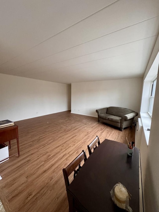 unfurnished dining area featuring wood-type flooring and lofted ceiling