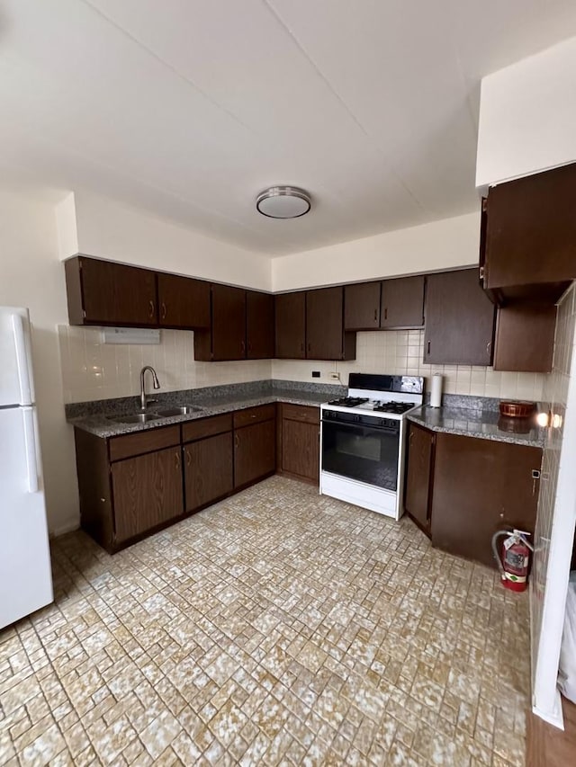 kitchen featuring sink, backsplash, white refrigerator, dark brown cabinetry, and range with gas stovetop