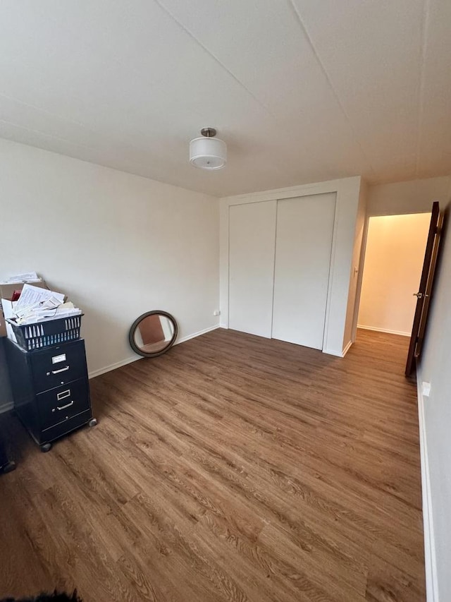 unfurnished bedroom featuring dark hardwood / wood-style flooring and a closet