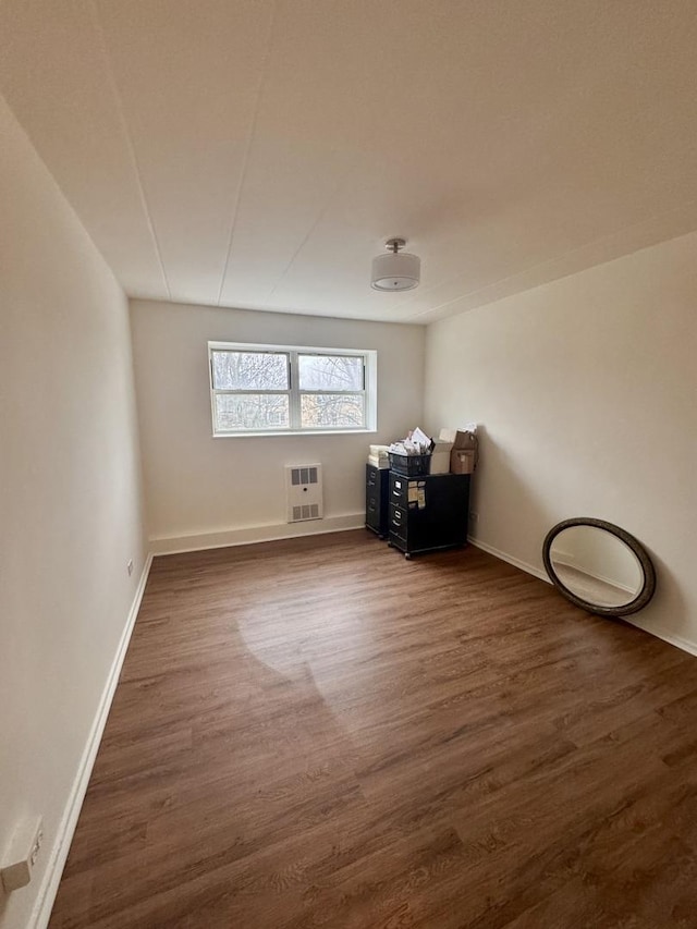 interior space featuring dark hardwood / wood-style flooring and heating unit