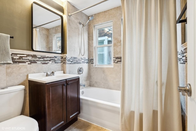 full bathroom with toilet, shower / bath combo, tile walls, and vanity