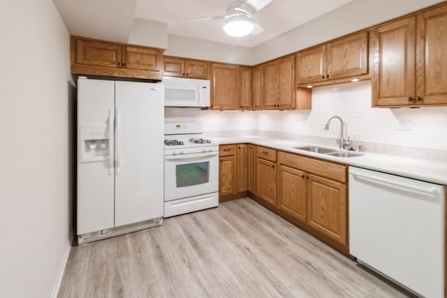 kitchen with sink, white appliances, light hardwood / wood-style flooring, ceiling fan, and backsplash