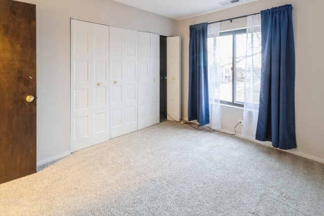 unfurnished bedroom with multiple windows, carpet floors, and a closet