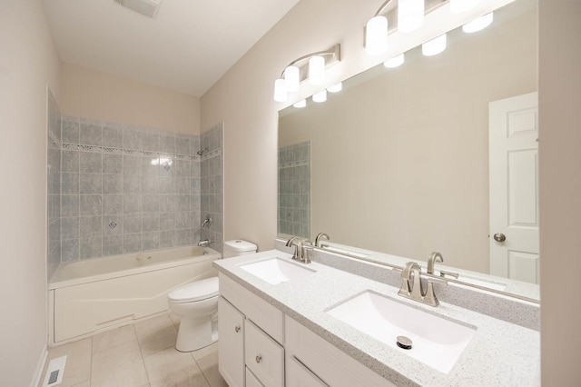 full bathroom with tiled shower / bath, vanity, tile patterned floors, and toilet