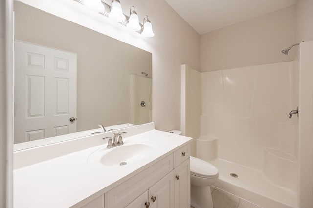 bathroom featuring toilet, vanity, and walk in shower