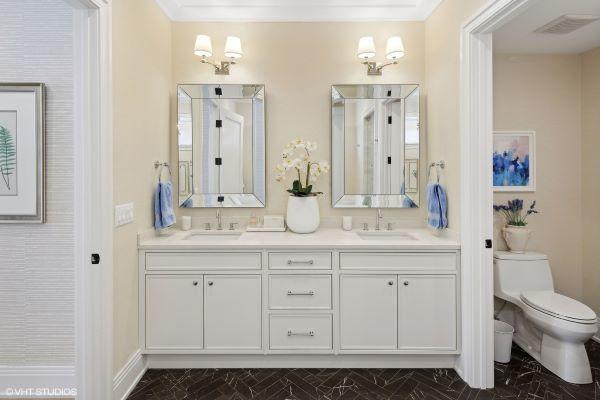 full bath featuring toilet, double vanity, a sink, and visible vents