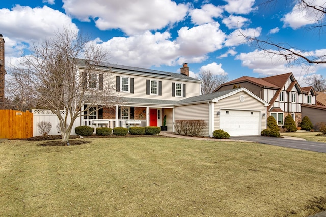 view of front of house featuring a garage, a front yard, solar panels, and a porch