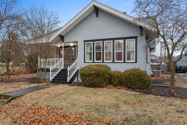 view of front facade with a porch, a front yard, and central air condition unit