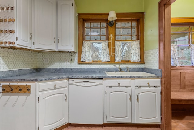 kitchen with white cabinetry, white dishwasher, backsplash, and a sink