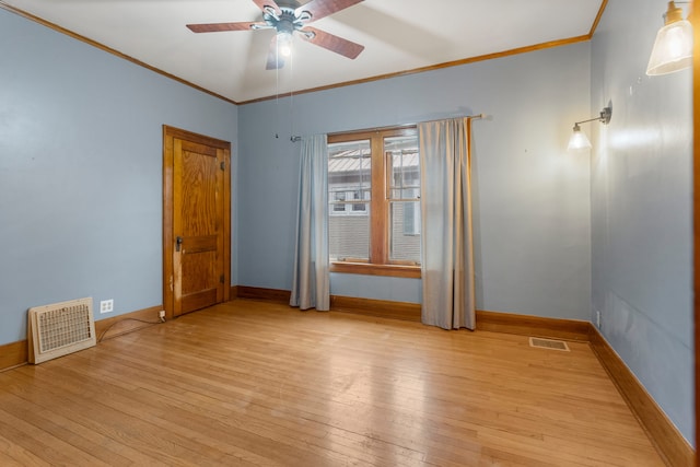 empty room with light wood-style flooring, visible vents, and crown molding