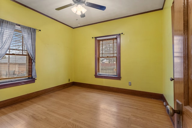 unfurnished room with crown molding, baseboards, and wood finished floors